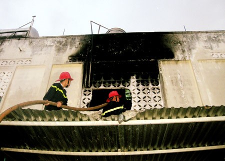 Two firefighters battle the blaze at a shopping center in Pleiku City on July 4. (Photo:SGGP) Two firefighters battle the blaze at a shopping center in Pleiku City on July 4. (Photo:SGGP)